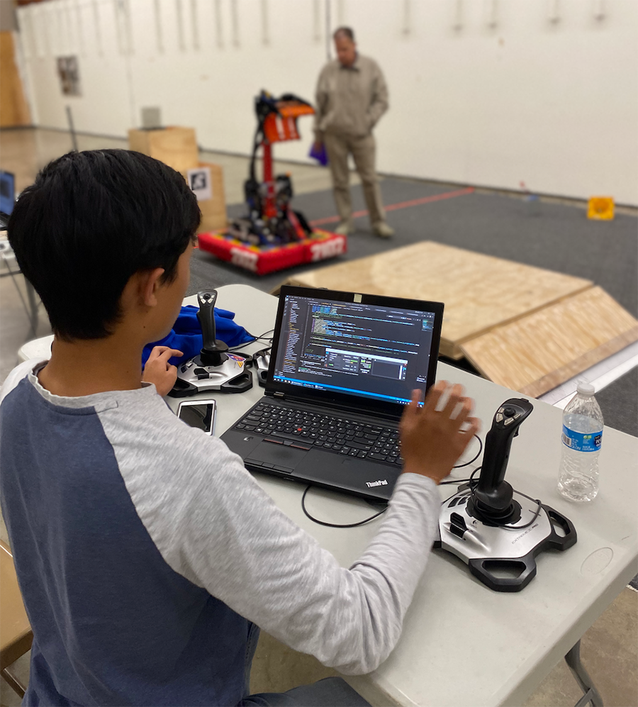SDA Robotics student programming a robot